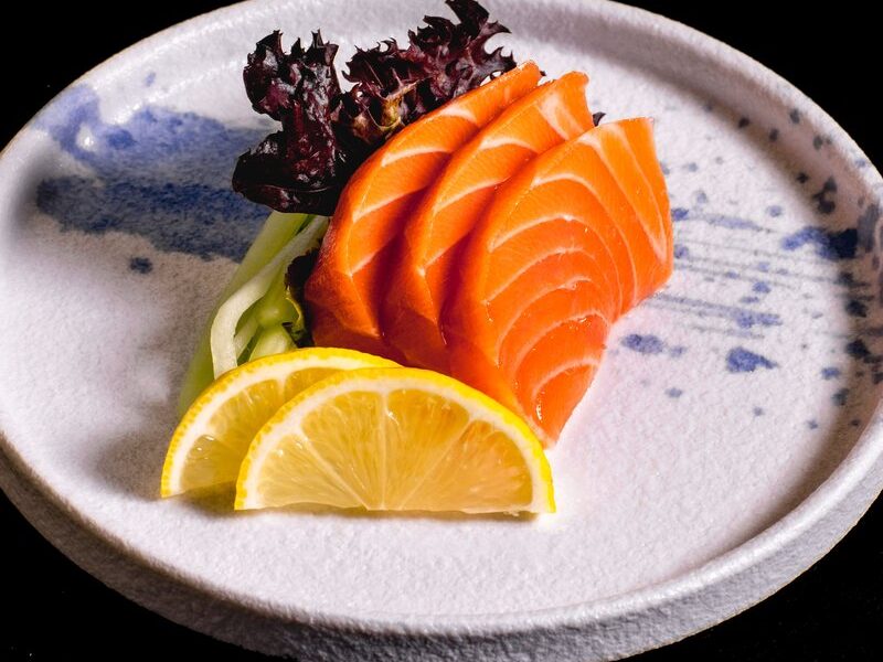 Salmon sashimi with lemon on a hand-painted plate